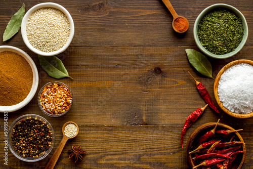 Fototapeta Naklejka Na Ścianę i Meble -  Colorful herbs and spices in bowls for cooking. Pepper chili, laurel leaf, salt and curry