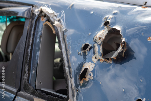 Car riddled with bullets. War of Russia against Ukraine. A car of civilians shot by the Russian military during the evacuation of women and children. Traces of bullets and fragments of shells.