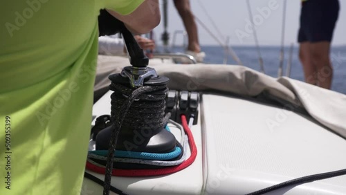 Man work with winch on the yacht. 