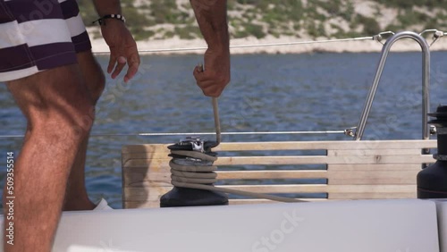 Man work with winch on the yacht. 