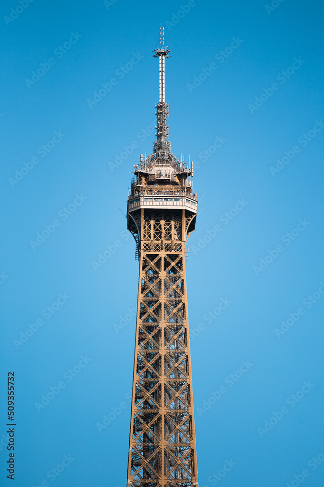 Close-up silhouette of the eiffel tower against the blue sky on a sunny day - details of the steel structure of the symbol of Paris and France Close-up silhouette of the eiffel tower against the blue sky on a sunny day - details of the steel structure of the symbol of Paris and France