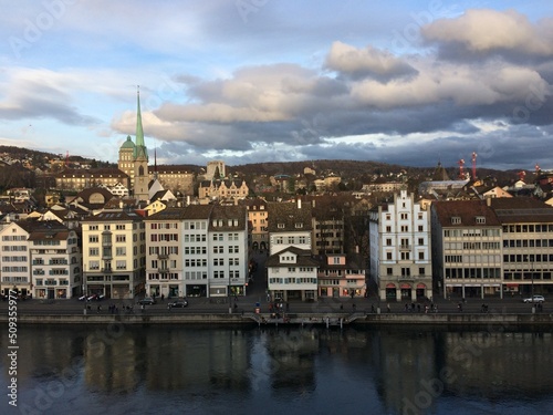 View from the highest point of the old town in Zürich over the Limmat River until the Zürichberg. Buildings are reflected in the water and the ETH and Polyterrase also appear. © Gustavo