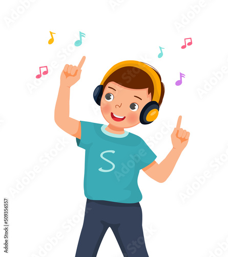 Happy cute little boy dancing while listening to music with headphone 