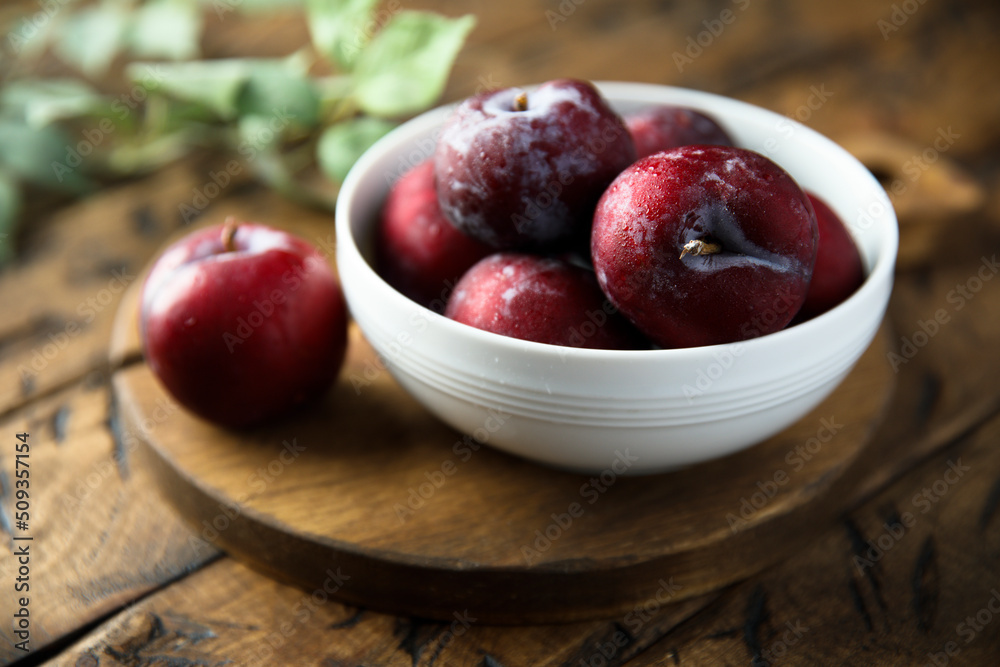 Fresh ripe plums in a white bowl Fresh ripe plums in a white bowl
