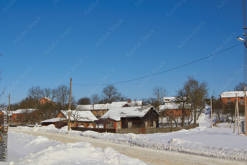 village in winter,winter rural street landscape with old houses and road