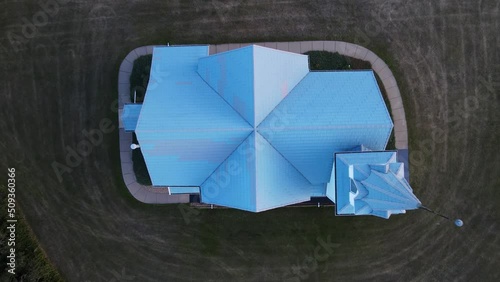 The blue tile roof of a freshly renovated country church in the remote part of south Alberta. High angle rising shot photo