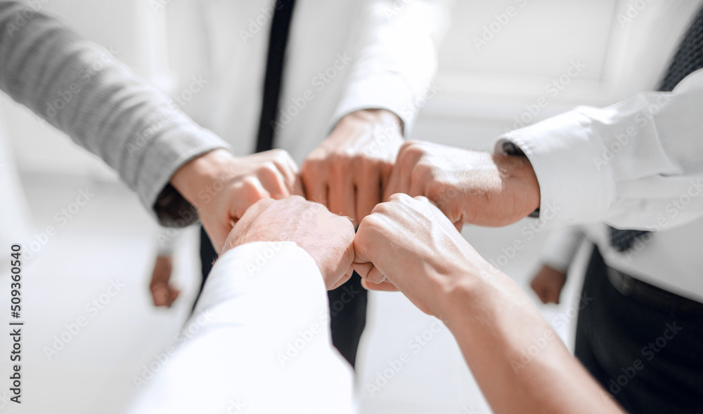 Close up .businessman and businesswoman making a fist bump on building background