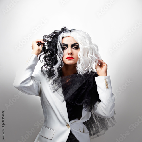 A fatal beauty in a daring fashion image with black and white hair. A rebellious stylish image for Halloween. photo