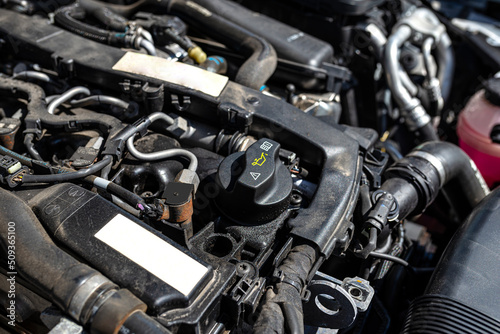 Engine compartment in a diesel car, visible closed oil filler in black and engine parts.