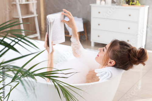 Papier peint Beautiful woman reading book while enjoying bubble bath at home