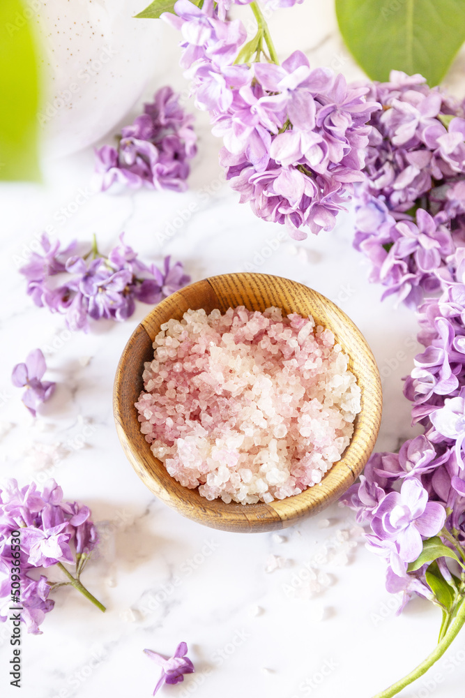 Spa setting. Organic spa sea salt and lilac flowers on a marble. Spa setting. Organic spa sea salt and lilac flowers on a marble.