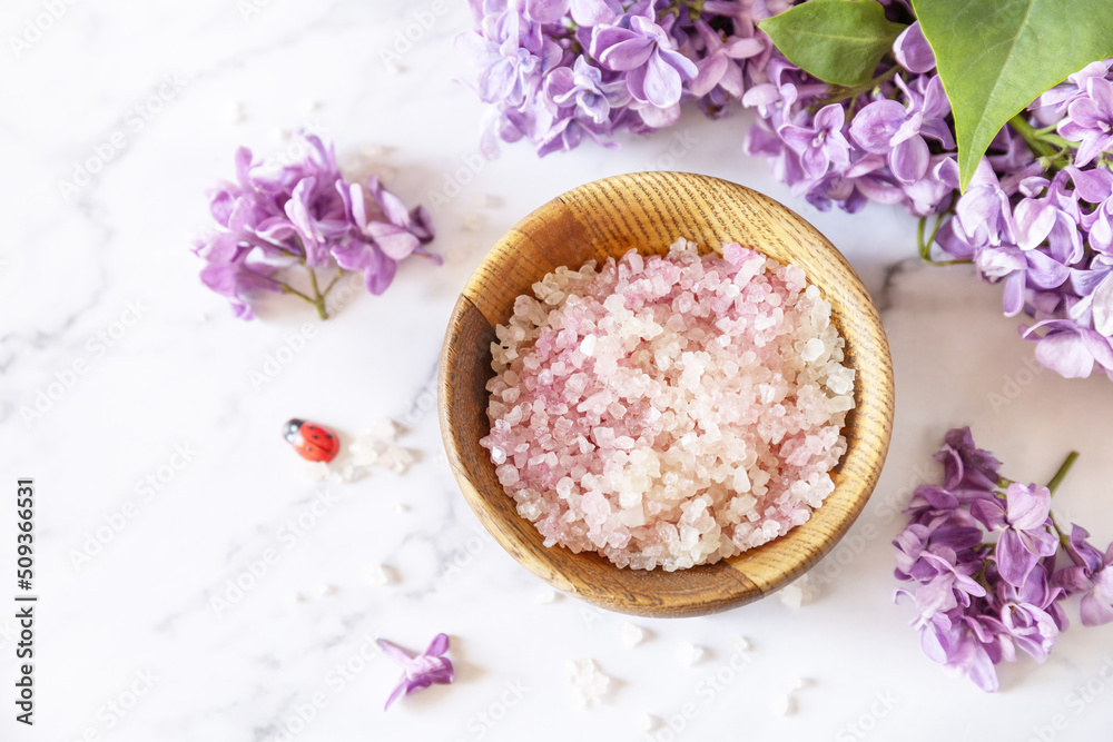 Spa setting. Organic sea salt and lilac flowers on a marble. Copy space. Spa setting. Organic sea salt and lilac flowers on a marble. Copy space.
