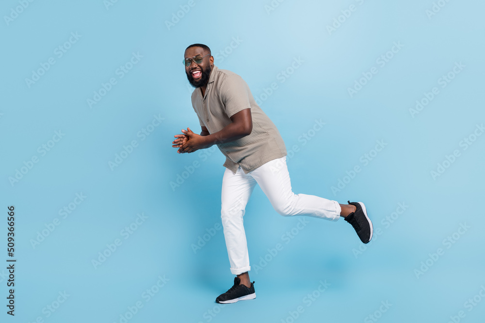 Full body portrait of satisfied glad person dancing have good mood isolated on blue color background Full body portrait of satisfied glad person dancing have good mood isolated on blue color background