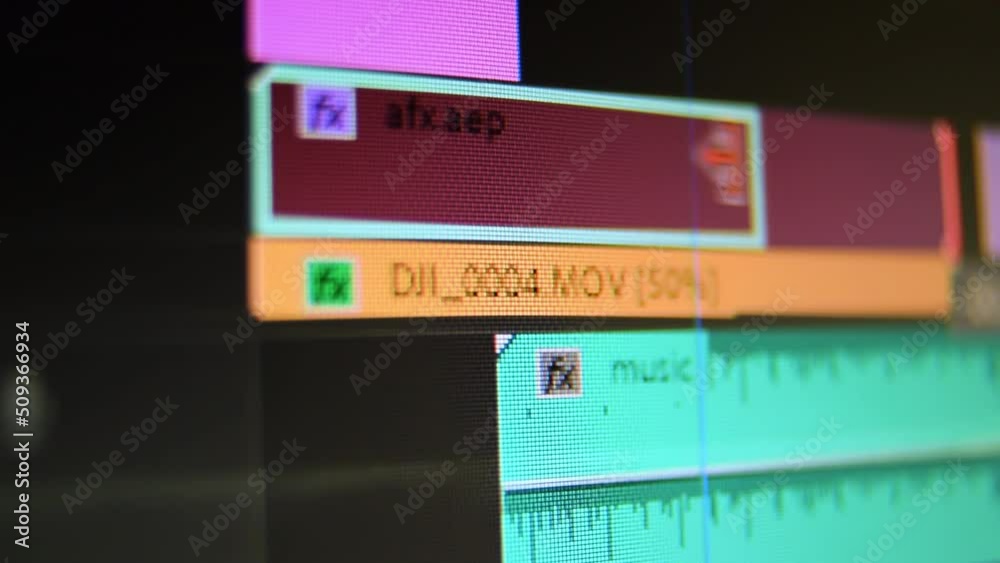 Video editing screen software high contrast.  Dolly shot of computer screen in audio video editing software. Moving cutting clips of film music sound. Low depth of field.