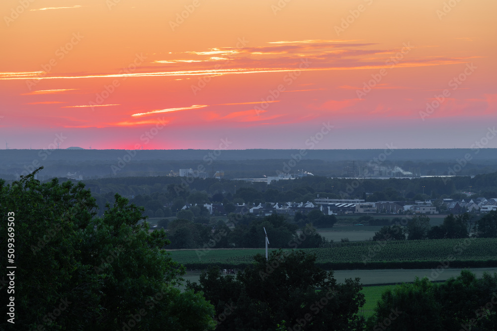 A wonderful sunset with a few fluffy clouds, covering the rolling hills of south Limburg in the Netherlands with an orange and golden glow, creating a magical atmosphere over the agricultural fields. A wonderful sunset with a few fluffy clouds, covering the rolling hills of south Limburg in the Netherlands with an orange and golden glow, creating a magical atmosphere over the agricultural fields.