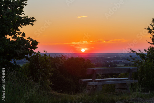 A beautiful sunset late Spring over the rolling hills from south Limburg. The wooden bench is an idyllic place for couples to enjoy a romantic evening overlooking to landscape.