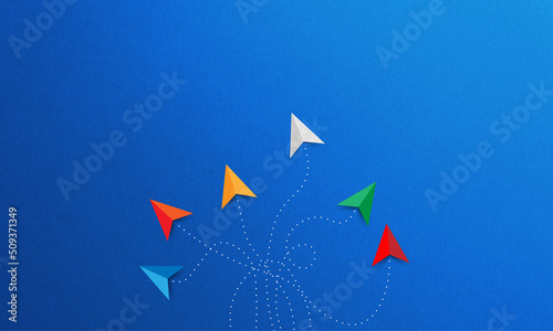 A group of different colored paper planes flying in different directions on a blue background. Business for innovative solution concept. Freedom concept.
 photo