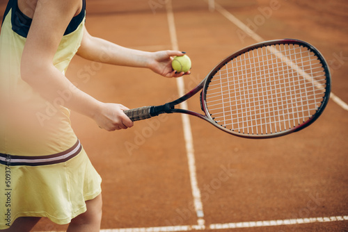 Woman playing tennis at the court © Petro