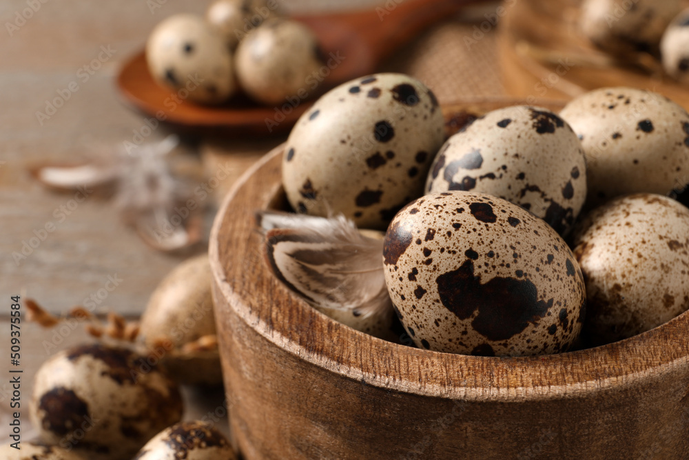Wooden bowl with quail eggs on table, closeup Wooden bowl with quail eggs on table, closeup
