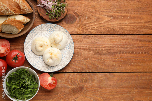 Delicious burrata cheese on wooden table, flat lay. Space for text