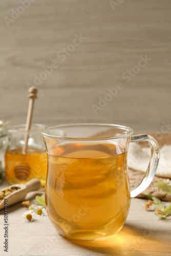 Freshly brewed tea and dried herbs on white wooden table