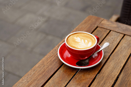 Cup of aromatic coffee on wooden table outdoors. Space for text