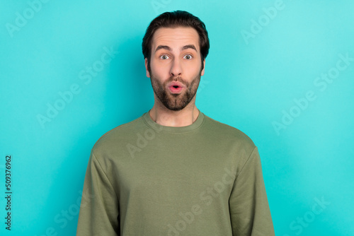 Photo of excited brunet millennial guy look camera wear green pullover isolated on teal color background