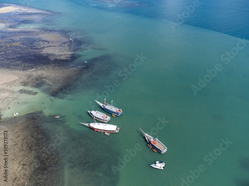 Schooner boat tour on the coral reef in the middle of the sea, Porto Seguro, Bahia, Brazil - natural beauty aerial drone view  photo