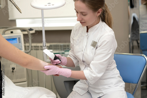 Doctor dermatologist examines skin of patient. Dermatoscopy, prevention of melanoma, skin cancer.