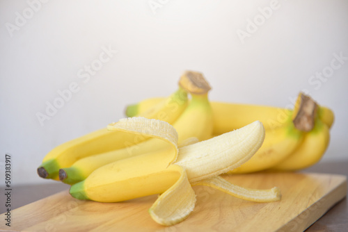 ripe yellow bananas on wooden background. soft selected focus. top view yellow fruit, yellow bananas in a wooden tray. concept on healthy food background. food, diet, vitamins,