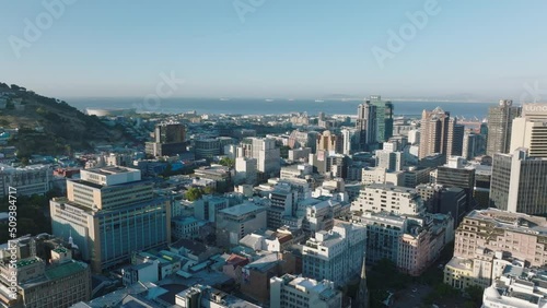 Aerial ascending footage of high rise office buildings in city centre. Sea bay with seaport in background. Cape Town, South Africa