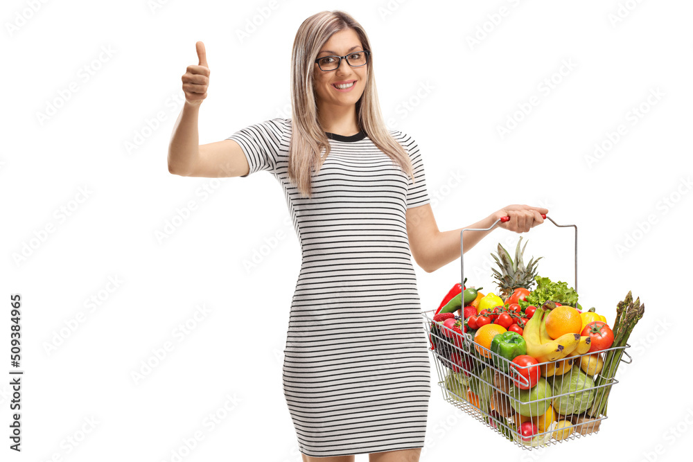 Woman with a shopping basket with fruits and vegetables showing thumbs up Woman with a shopping basket with fruits and vegetables showing thumbs up