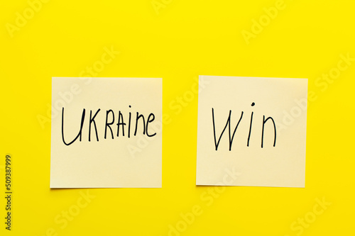 top view of paper cards with ukraine win lettering yellow background.