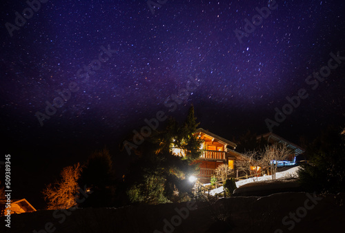 French village with wooden houses chalets over stars in the sky