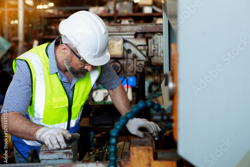 Caucasian male engineer Inspection, control, maintenance, machinery for the production of metal parts in industrial plants © atitaph