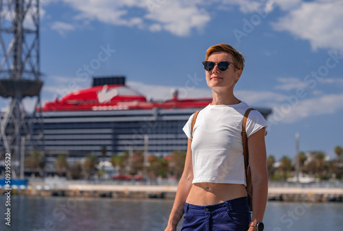 Canvas Print Woman traveler in the Port Vell  with large Virgin cruise liner on the background