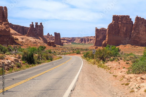 Three Gossips and Courthouse Towers rocks in the Arches National Park, Utah, on a beautiful sunny day of spring. Road winding through scenic Utah desert. Driving in the American southwest.
