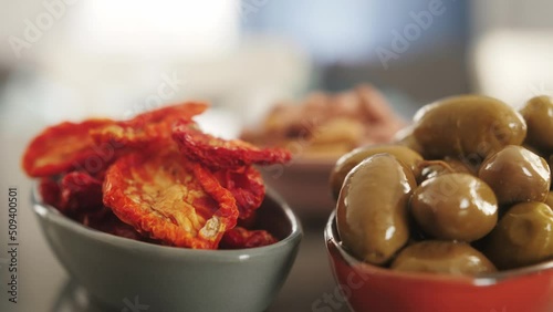 Italian cuisine with traditional snacks, delicious tapas, olives, dried tomatoes.