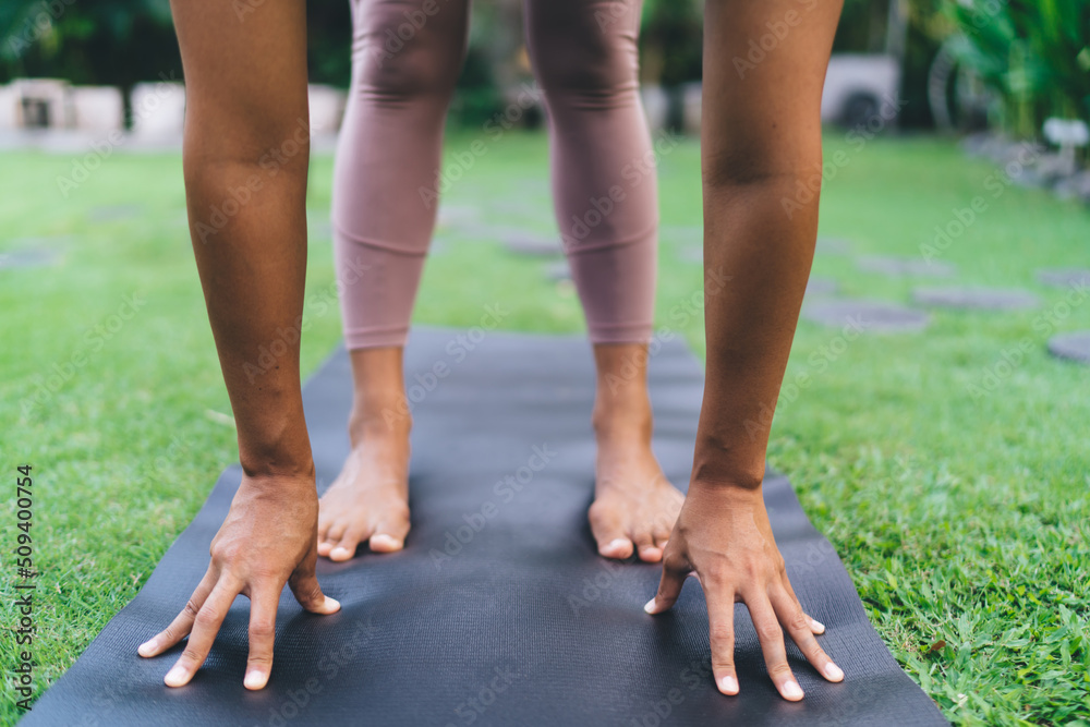 Girl practicing yoga on fitness mat in yard