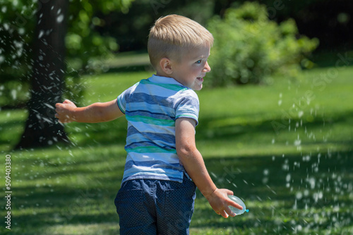 Little boy runs dring a water balloon game