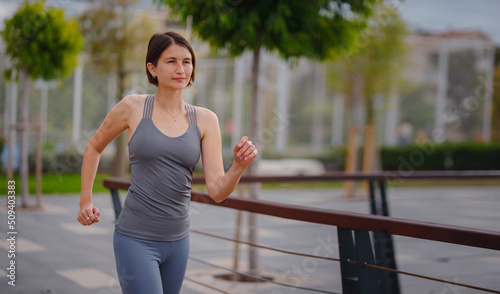 outdoor sports, workout and wellness concept. asian young strong, confident woman in sportive clothes in green park.