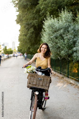 Woman with flowers in the basket of electric bike