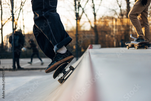 Young skateboarder legs riding skateboard at city 