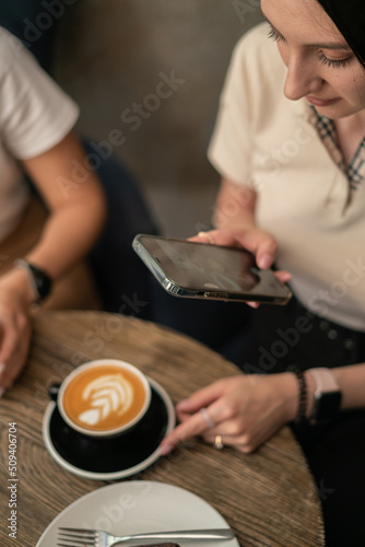 girl takes a picture of coffee on the phone