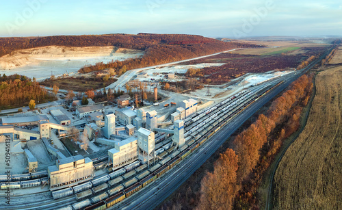 Aerial view of cargo train loaded with crushed stone materials at mining factory. Railway transportation of grinded limestone ore