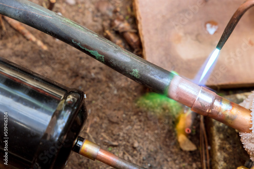 Fotografie Closeup professional master plumber soldering copper pipe with blow torch