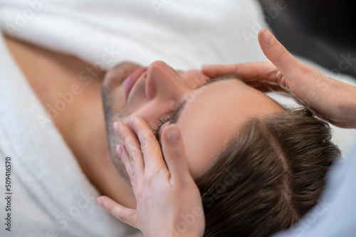 Young man having face massage in a beauty salon