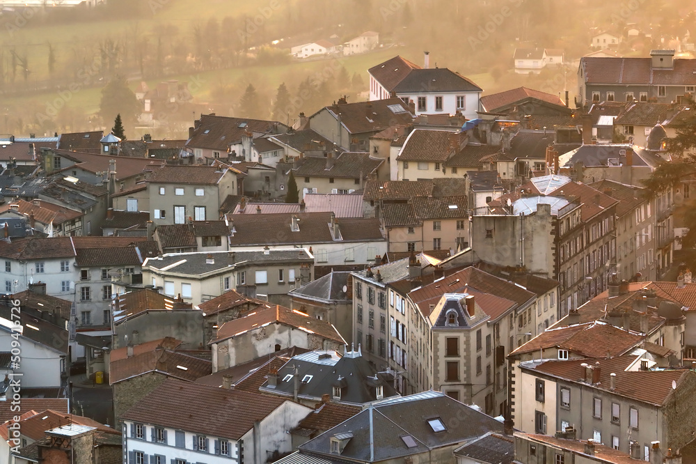 Fototapeta premium Aerial view of dense historic center of Thiers town in Puy-de-Dome department, Auvergne-Rhone-Alpes region in France. Rooftops of old buildings and narrow streets at sunset
