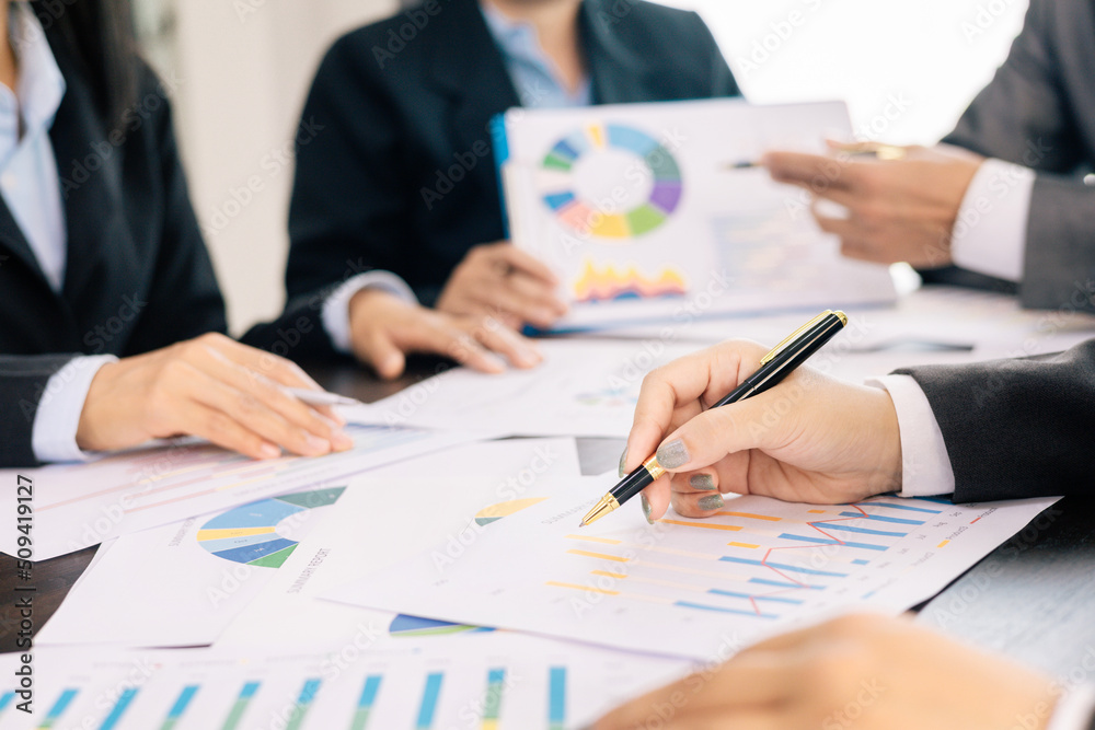 business team Analysis graph to discuss company financial statistics, brainstorm ideas, Businessman holding a pen on graph paper, Teamwork Business meeting concept.