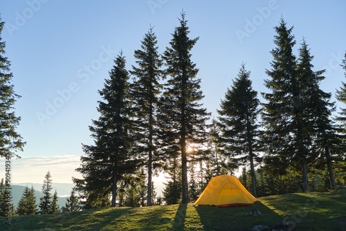 Tourist camping tent on mountain campsite at bright sunny evening. Active tourism and hiking concept